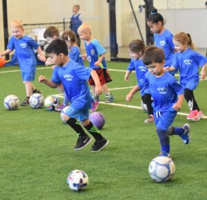 Toddlers playing on indoor turf field during Active Childcare at Westmont Yard in Westmont IL