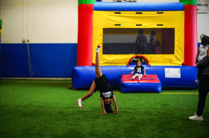 Toddlers playing on inflatables in The Playroom indoor playground at Westmont Yard in Westmont IL