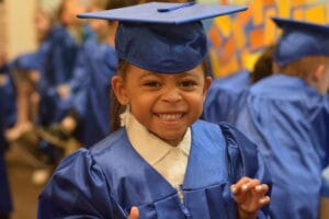 Preschool graduation moment at Westmont Yard daycare in Westmont, child in cap and gown ages 4 to 6