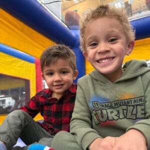 Child in bouncy houses and climbing 5 level play tower during large motor time at Active Childcare Westmont Yard