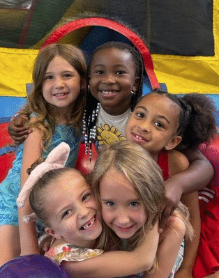 Group of kids at a birthday party at Westmont Yard indoor sports complex in the large field inflatables